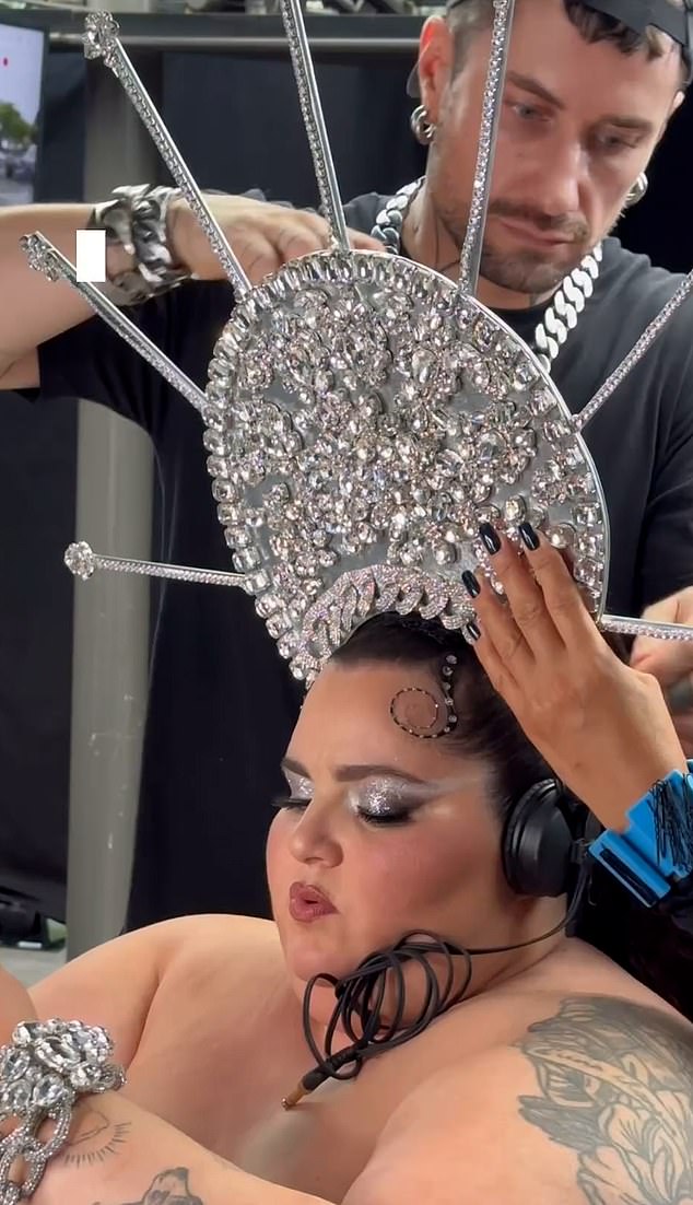 Barbara Butch is photographed preparing for her performance, as stylists place her striking headdress on.