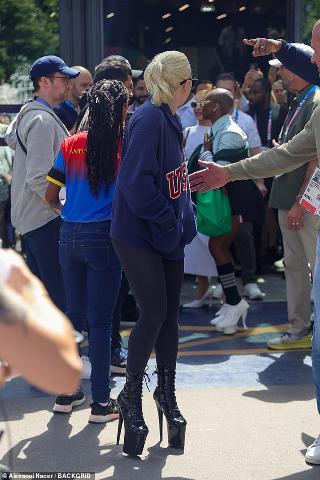 As she made her way to the stands, Gaga wore black leggings, a casual navy USA jersey and massive pointy-toed platform boots.