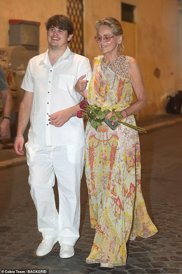 She added height to her look with a pair of knitted wedges, while her youngest son, 18, sweetly helped her walk down the cobblestone streets by linking arms.