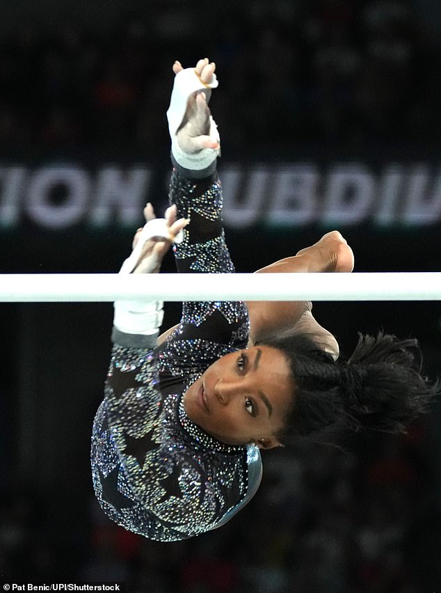 Biles reaches during her routine on the uneven bars during Sunday's qualifying round.