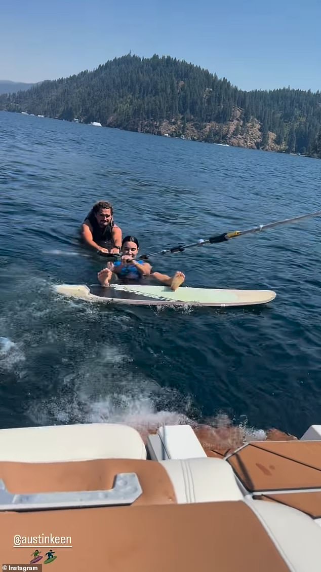 Austin was behind her in the photo on the boat and while she was wakeboarding in the water.