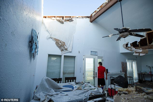 A contractor inspects a Dallas client's home for structural damage after Hurricane Beryl moved through the area in Galveston, Texas, July 8, 2024.