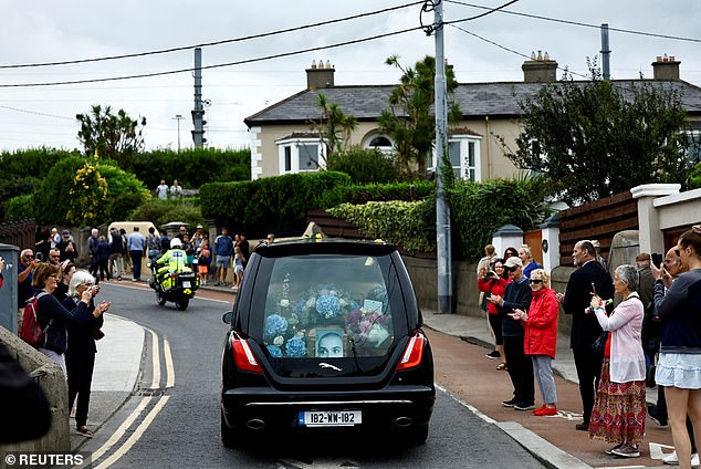 Pictured: Onlookers applaud as Sinead O'Connor's coffin passes her former home.