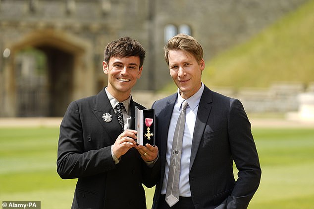 Dustin appears to be a loving husband as he supports Tom while he receives his OBE.