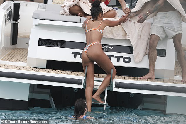 She took a dip in the sea and then some of her friends who were already on the boat helped her out of the water.