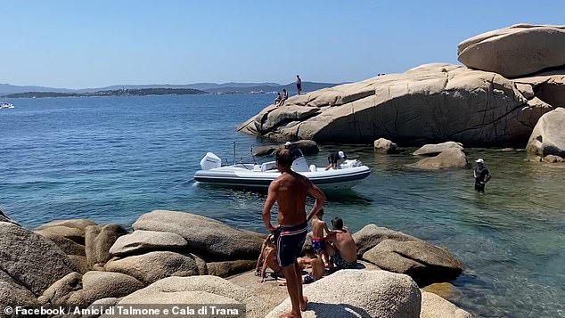 Bathers watch as members of the Italian coast guard arrive to put an end to the party