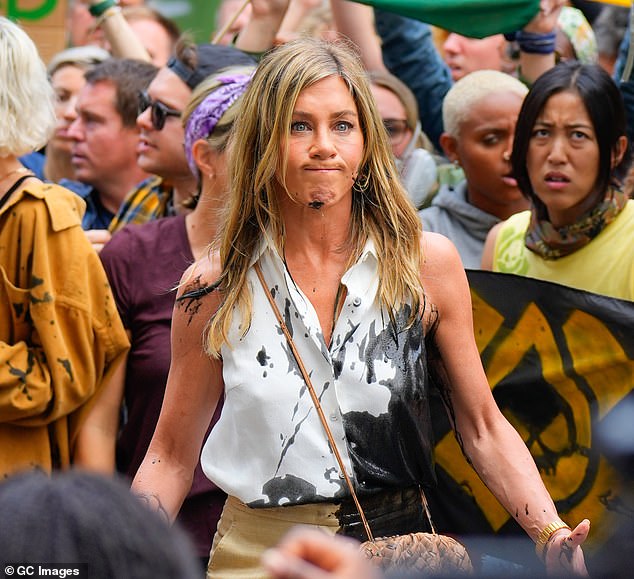 While on set in New York City, the 55-year-old actress looked convincingly shocked when a climate change protester dumped a bucket of fake oil all over her body.