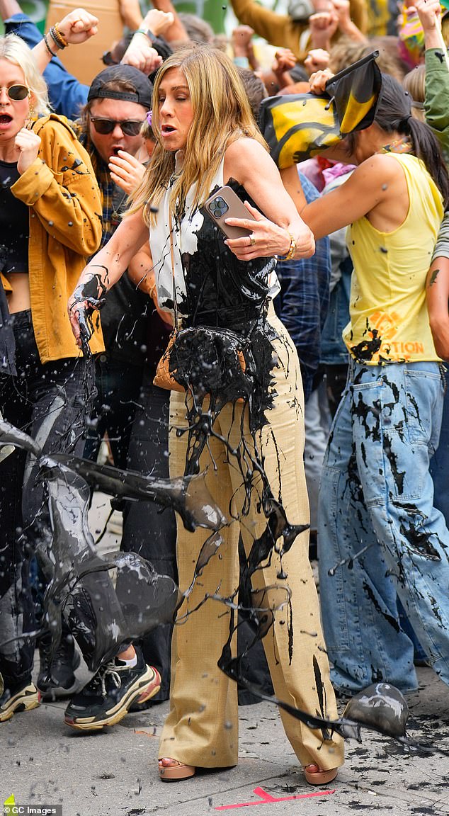 Just moments after arriving on set looking flawless, she was spotted with the black tar-like substance covering her white blouse and khaki pants and dripping down her arms.