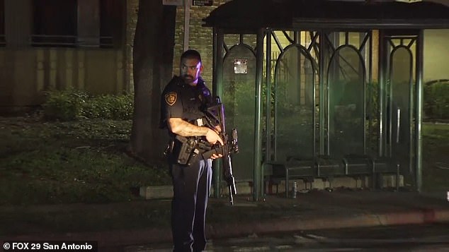 An armed police officer stands guard after three police officers were shot while responding to a domestic violence call in San Antonio on Sunday morning.