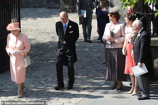 The Queen and Prince Philip photographed walking alongside the bride and groom's parents