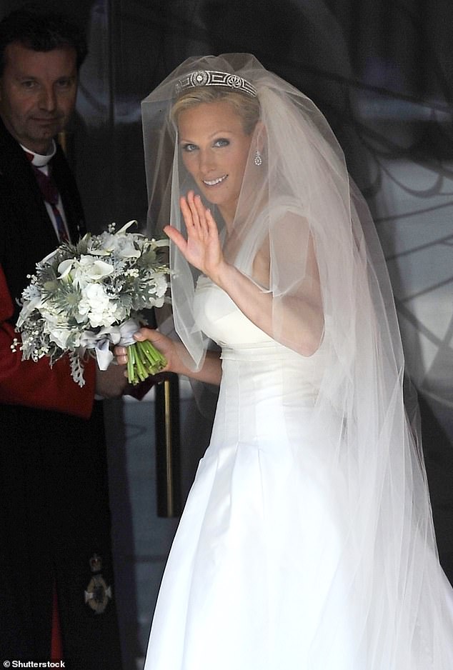 Zara photographed holding a white floral arrangement at her wedding.