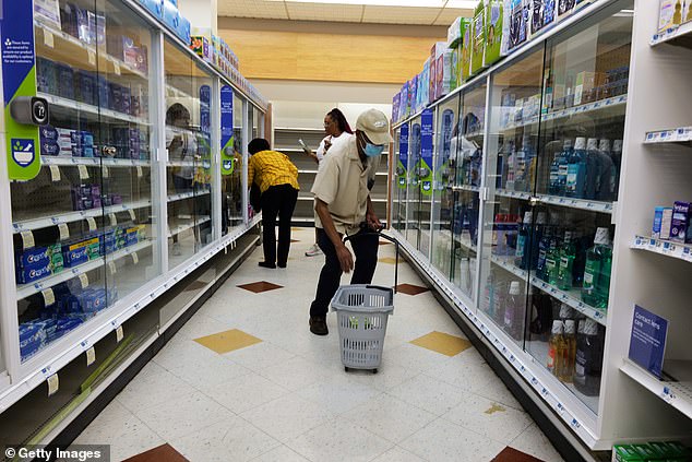 Three people browse the empty shelves of a Brooklyn Rite Aid in August 2023, months before it filed for bankruptcy.