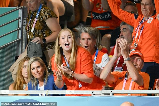 The Dutch royal family are pictured watching a handball match on day four of the 2024 Olympic Games in Paris. Of the two Dutch sisters, Princess Catharina-Amalia (second from right), 20, looked the most enthusiastic in a matching orange button-down shirt with her mother-in-law's blonde hair falling over her face.