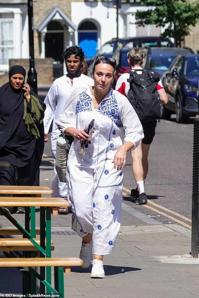 Amanda looked chic in a white and blue linen summer dress, paired with matching sneakers and a clutch.