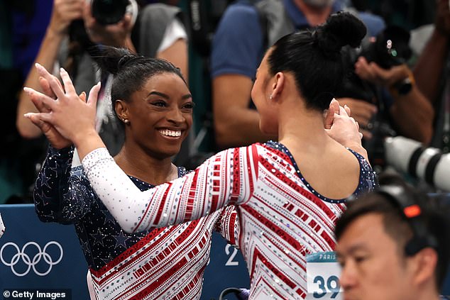 Team USA's Sunisa Lee reacts with teammate Simone Biles after their routine