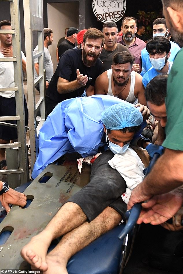 Beirut medical staff treat a wounded man following an Israeli attack. Tensions were high as paramedics were seen removing victims from several damaged buildings, including a hospital.