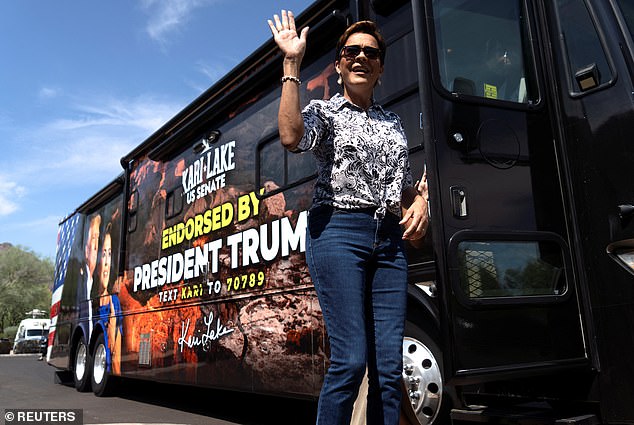 Lake greets members of the press before casting her ballot at Paradise Valley City Hall during the Arizona state primary election.