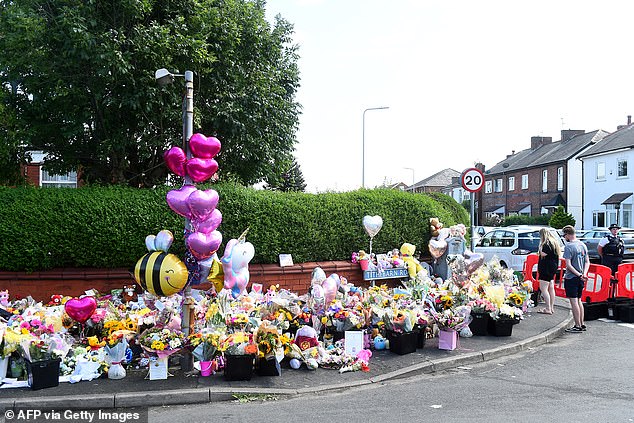 Today, floral offerings, balloons and stuffed animals covered the street near the police cordon.