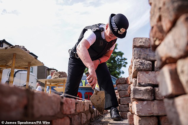 She was seen helping to repair a wall that was destroyed by rioters, who used the bricks as missiles at officers.