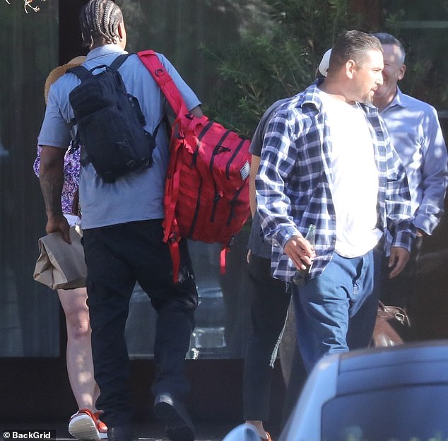 Paul opted for a loose white T-shirt with a blue and white checked button-down shirt on top, and added jeans and sneakers.