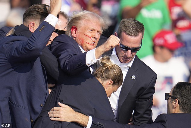 Blood is seen coming out of Donald Trump's ear where he said he was shot. Online trolls claimed the event was staged immediately after it happened