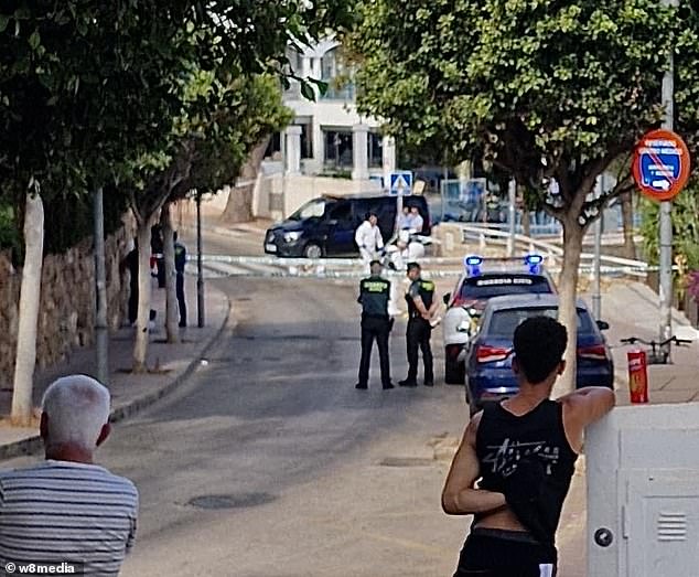 Mr Grant, a physiotherapist from Waterford, was found unconscious near Magaluf's famous Punta Bellena area, packed with late-night bars, clubs and lap dancing venues, at around 4.30am. Pictured: Neighbours watch police work at the scene today