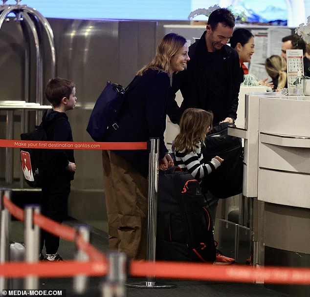 Arriving at Qantas Business Class check-in, Ally travelled in style in smart brown trousers and a black T-shirt, which she paired with a tailored blazer.