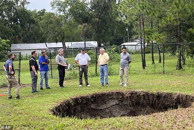 This photo shows a sinkhole that fatally swallowed a man sleeping in his own home in 2013. The sinkhole has since reopened for a third time, this time behind a wire fence and without causing damage to people or property.