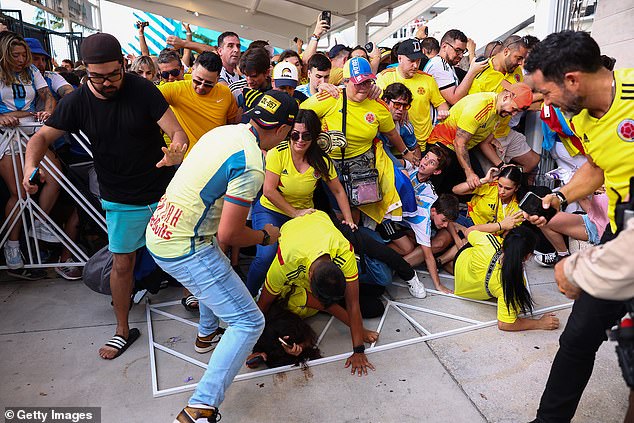 Colombia and Argentina fans try to pass the goal amid mass riots