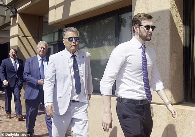 Rep. Mark Takano, D-Calif. (second from right) keeps a straight face as he ignores reporters' questions after the crucial meeting.