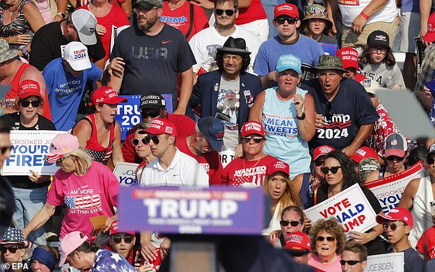 Former President Donald Trump falls to the ground after gunfire at his rally. Supporters in the background look around