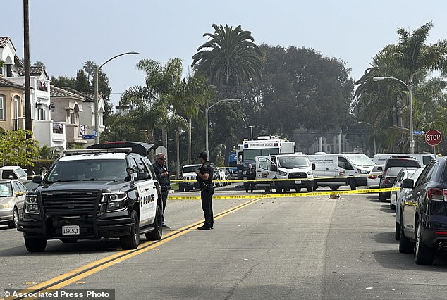 Police officers stand guard at the crime scene where police say several people were killed and injured in Huntington Beach