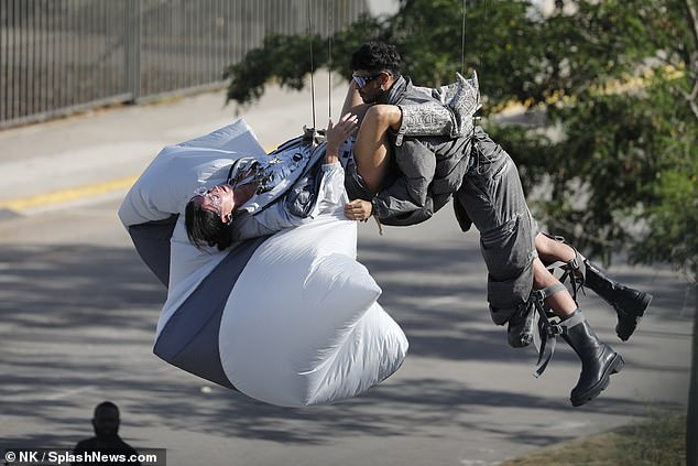 She was seen flaunting her body in a silver ensemble as she shared a saucy kiss with a male model before performing some sexy stunts with another man.