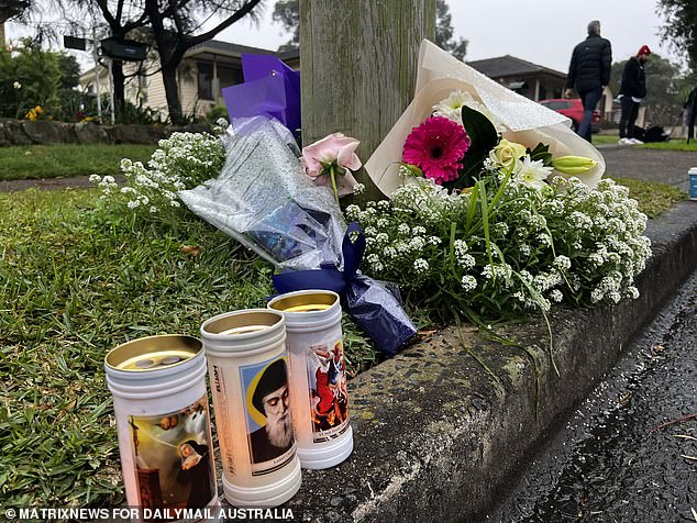 Shocked neighbors and friends placed flowers and candles outside the home on Monday.