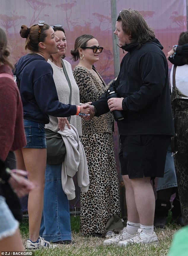 The singer, 27, seemed in good spirits as he was seen shaking hands with a fan backstage at Worthy Farm.