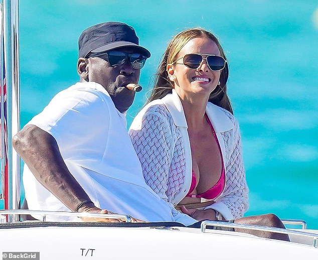 Jordan is seen smoking a cigar as they head towards a boat near the Ligurian Sea.