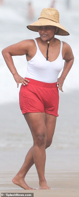 She donned a white swimsuit under a pair of red shorts for the sun-soaked occasion.