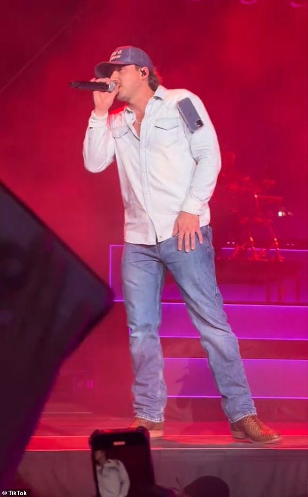 The controversial 31-year-old country singer brought his One Night At A Time world tour to Empower Field at Mile High, where he was performing his 2023 song Cowgirls when a fan suddenly threw his cell phone at his left shoulder.