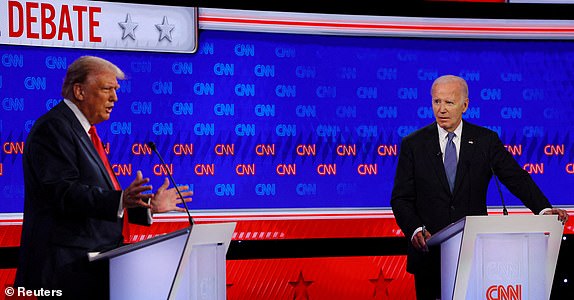 FILE PHOTO: Democratic presidential candidate Joe Biden listens as Republican presidential candidate and former U.S. President Donald Trump speaks during their debate in Atlanta, Georgia, U.S., June 27, 2024. REUTERS/Brian Snyder/File Photo