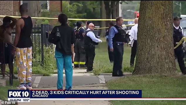 Officers and bystanders are pictured on a street where a horrific murder saw an 8-year-old boy killed along with two family members, while two other children, aged 5 and 7, were injured in the same shooting.