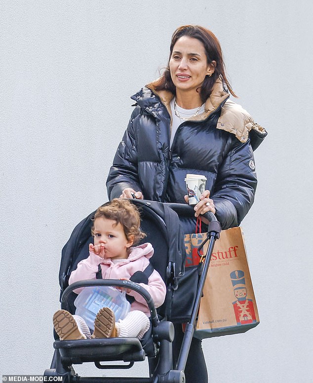 She kept herself comfortable in a pair of white sneakers and kept warm in the cold weather with a black puffer jacket with a beige lining.