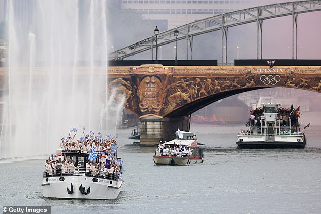 The first boats of athletes travel along the Seine River for the opening ceremony