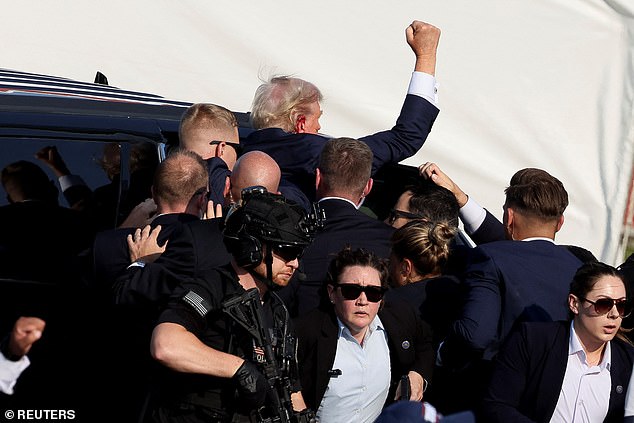 Secret Service personnel escorted a defiant Trump to a vehicle after he was injured.