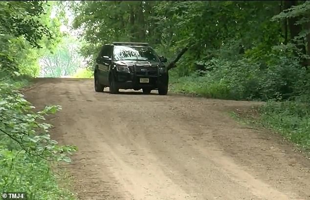 The search is underway in the rural town of Clyman, where police said Rasch made a number of suspicious purchases using his wife's credit cards before she was reported missing. A Douglas County sheriff's deputy is seen here searching the town.