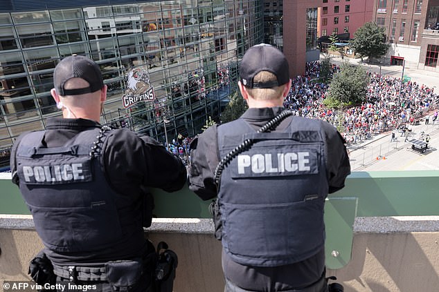 Police monitor the scene outside Van Andel Arena in Grand Rapids from the roof of another building.