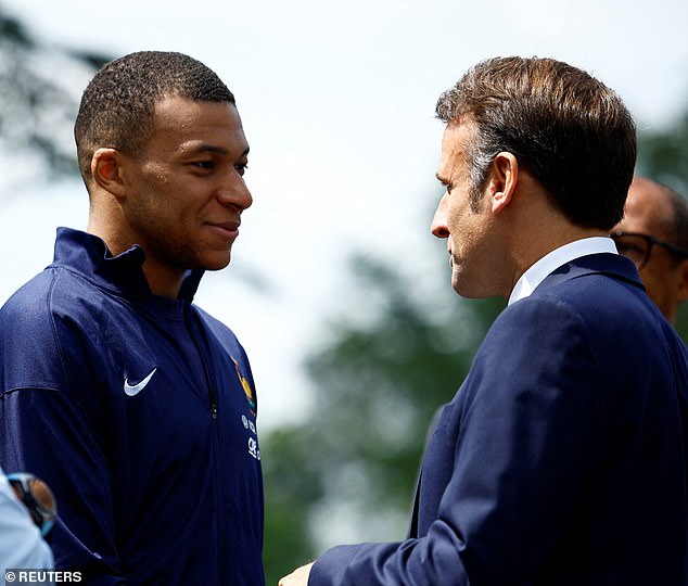 Macron (right) shakes hands with footballer Kylian Mbappé (left)