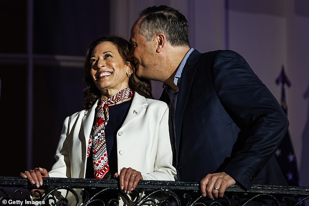 Doug Emhoff whispers to Vice President Kamala Harris as they watch fireworks over the National Mall from the White House balcony on July 4, 2024