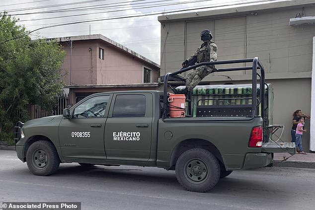 Mexican soldiers stand guard near the Tamaulipas Chamber of Commerce, where its president Julio Cesar Almanza was assassinated, in Matamoros, Mexico, Tuesday, July 30, 2024. (AP Photo/Veronica Cisneros)