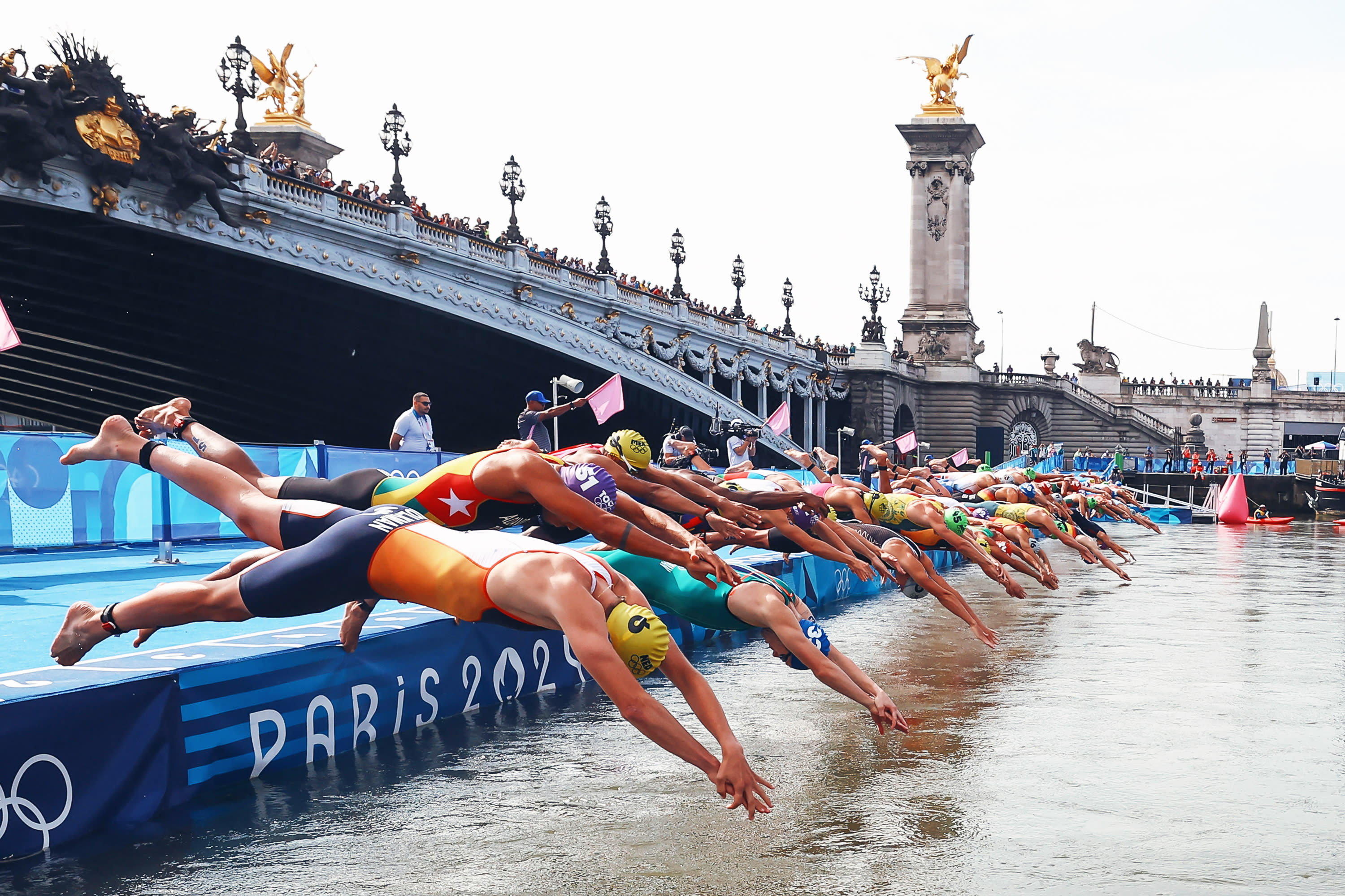 Athletes dive into the River Seine to start the swimming leg of the men's individual triathlon at the Paris 2024 Olympic Games in central Paris on July 31, 2024. (Photo by ANNE-CHRISTINE POUJOULAT/AFP via Getty Images)