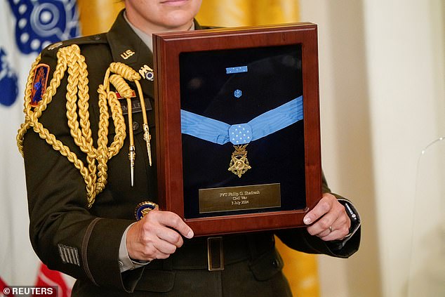 Austin said the panel will review each award. A Medal of Honor is seen here held aloft during a ceremony at the White House.